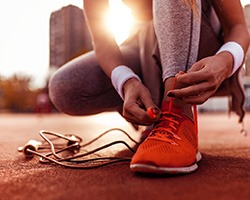 Woman lacing up shoelace on track