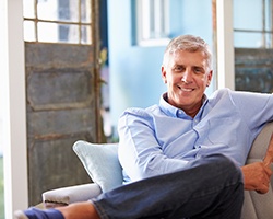 Man smiling while sitting on couch at home