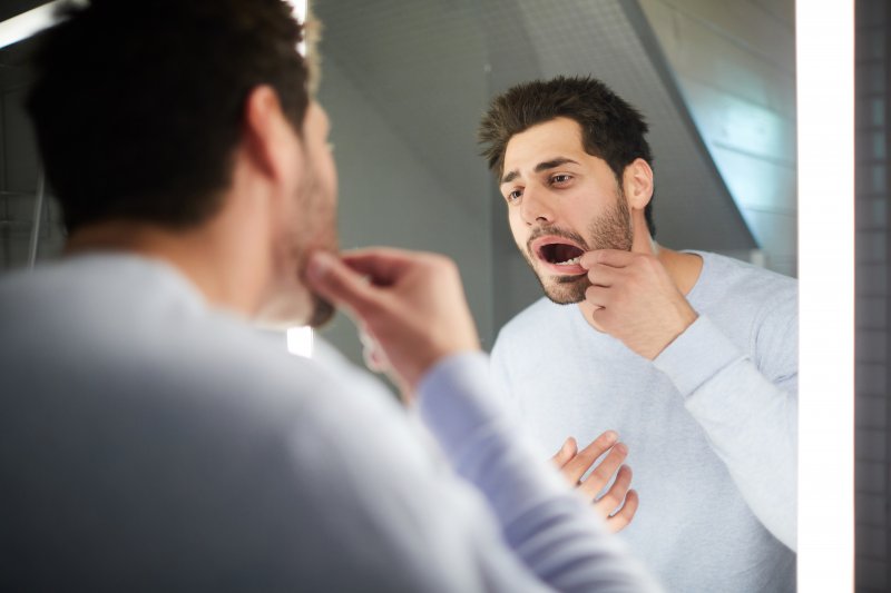 Patient checking their oral thrush in the mirror